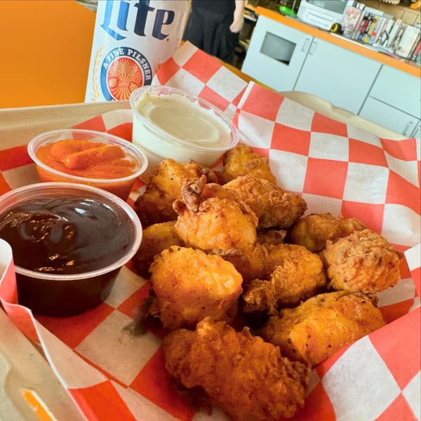 Crispy fried chicken nuggets with three dipping sauces and a Miller Lite beer can.