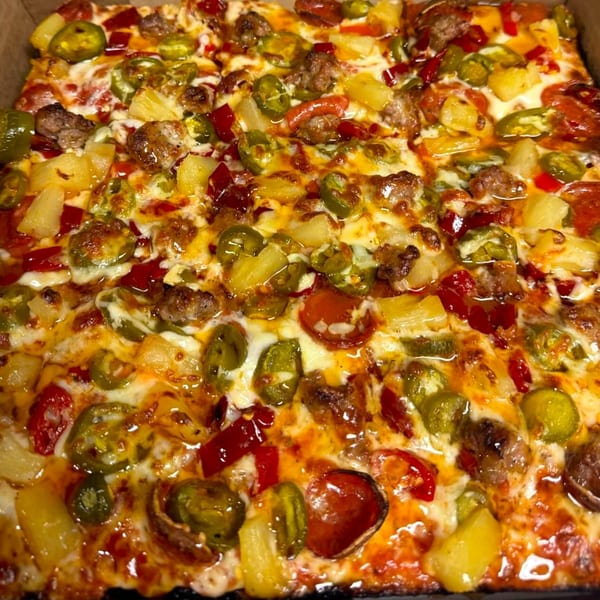 MT's Pizza King pizza with pepperoni, sausage, pineapple, jalapeños, and red peppers.